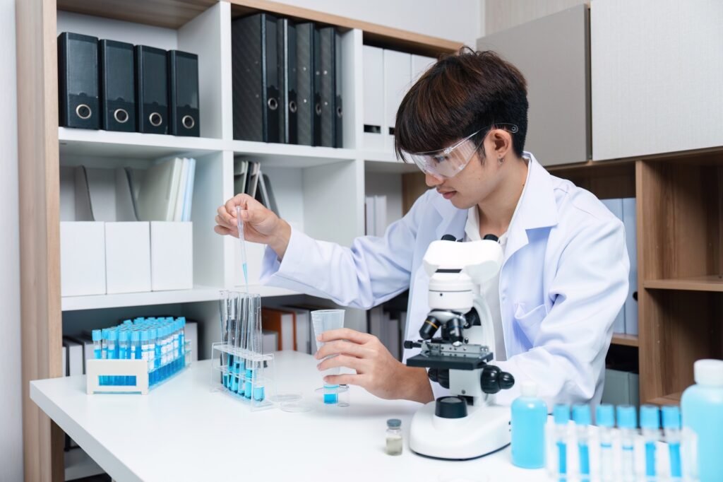 Young Researcher in Laboratory Examining Medicine Under Microscope for Medical Research and